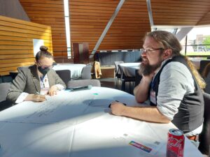 Attendees talk and take notes during a table discussion