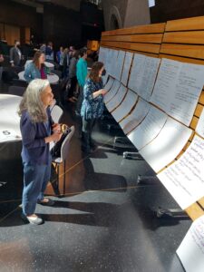 Forum attendees review the table discussion notes in a gallery walk